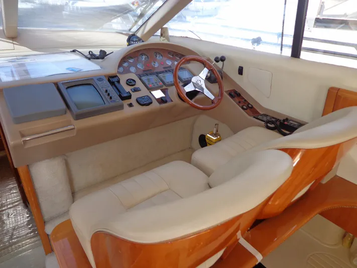  Yacht Photos Pics Interior helm of a 2001 Princess 56 yacht with leather seats and wooden steering wheel.