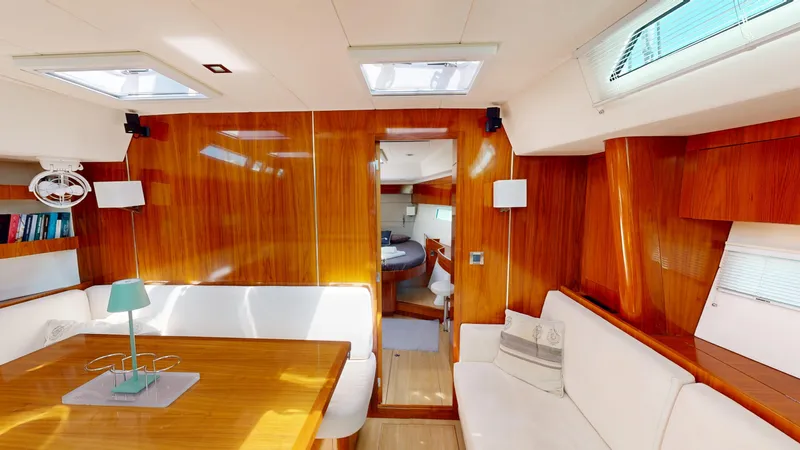  Yacht Photos Pics Luxurious interior of 2012 Amel 55 yacht with polished wood and white seating.