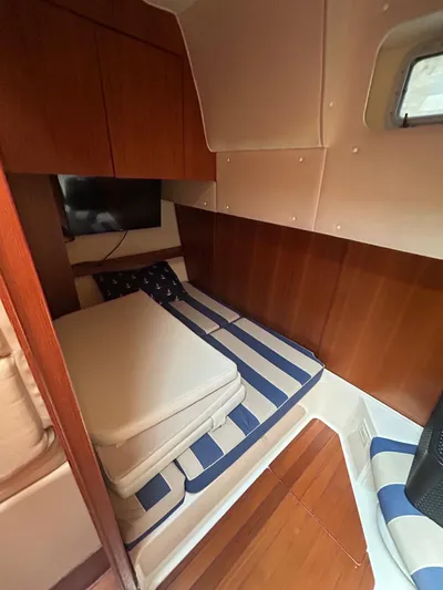  Yacht Photos Pics 2003 Tiara Yachts 4000 Express cabin with striped bedding and wooden interior.