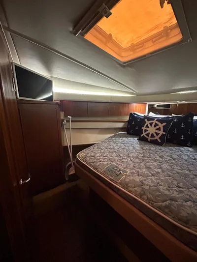  Yacht Photos Pics 2003 Tiara Yachts 4000 Express cabin with bed, nautical-themed pillows, and overhead hatch.