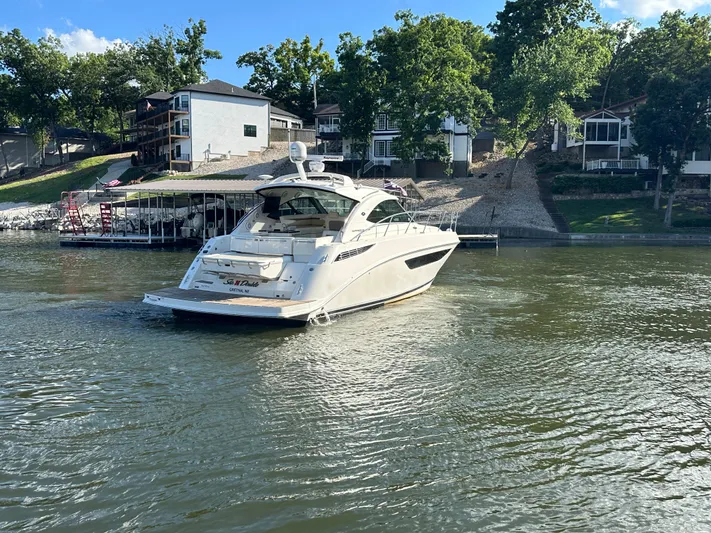  Yacht Photos Pics 2013 Sea Ray 410 Sundancer yacht on a serene lake near waterfront homes.
