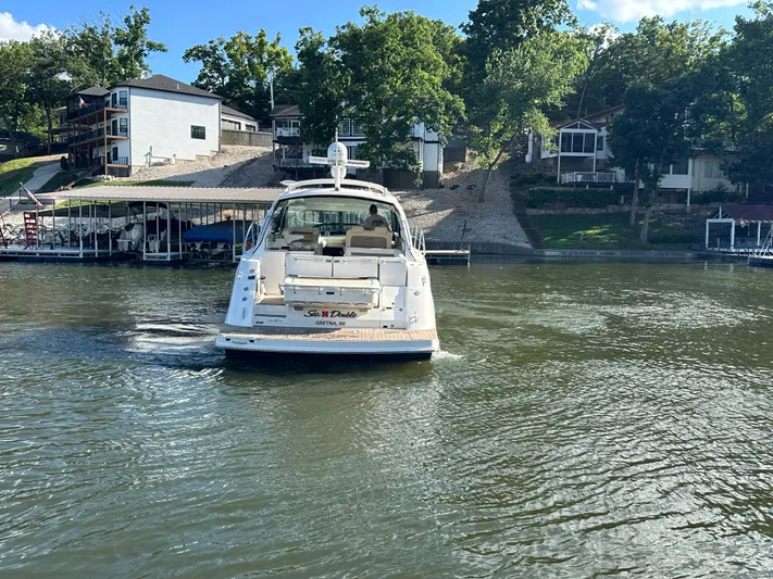  Yacht Photos Pics 2013 Sea Ray 410 Sundancer yacht cruising on a lake near waterfront homes.