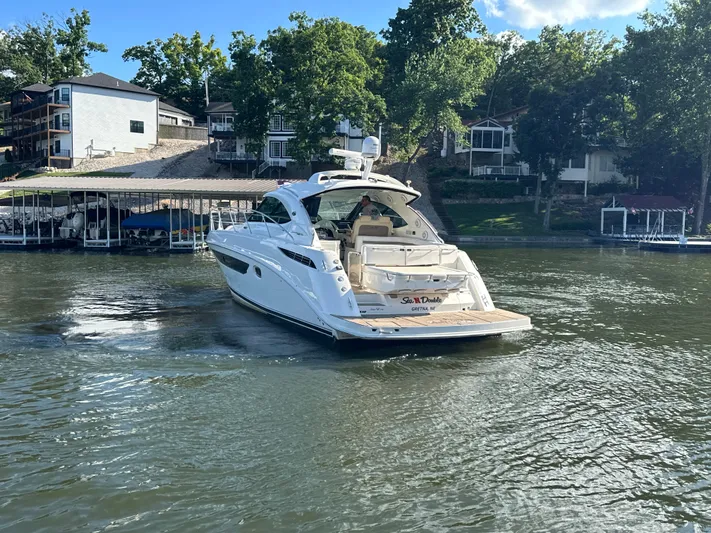  Yacht Photos Pics 2013 Sea Ray 410 Sundancer yacht cruising on a lake near waterfront homes.