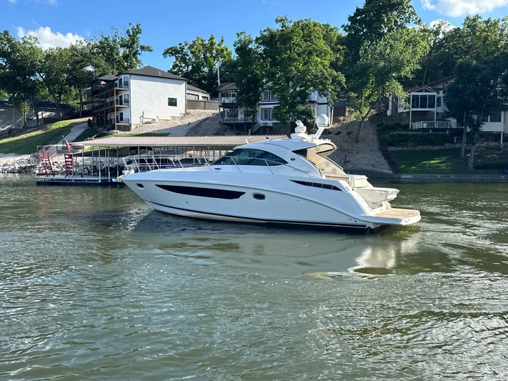  Yacht Photos Pics 2013 Sea Ray 410 Sundancer yacht on a calm lake near waterfront homes.