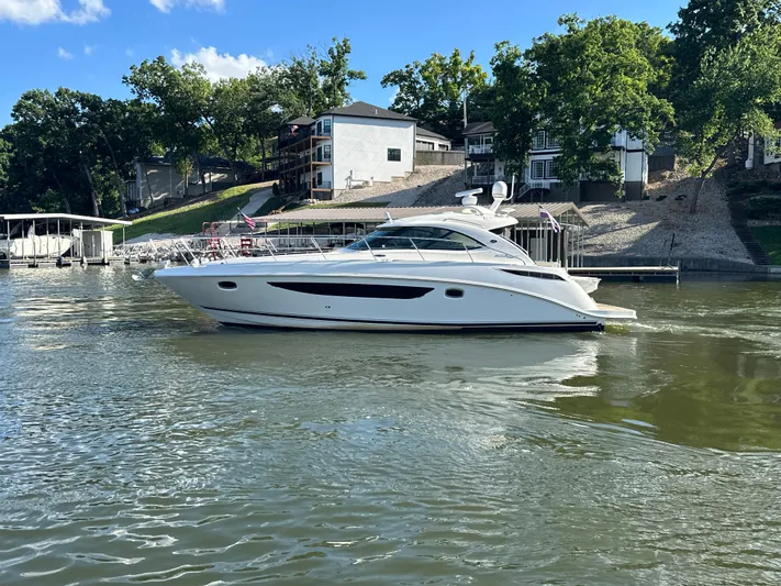  Yacht Photos Pics 2013 Sea Ray 410 Sundancer yacht on a calm lake near waterfront homes.
