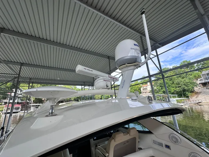  Yacht Photos Pics 2013 Sea Ray 410 Sundancer with radar and satellite equipment under a covered dock.