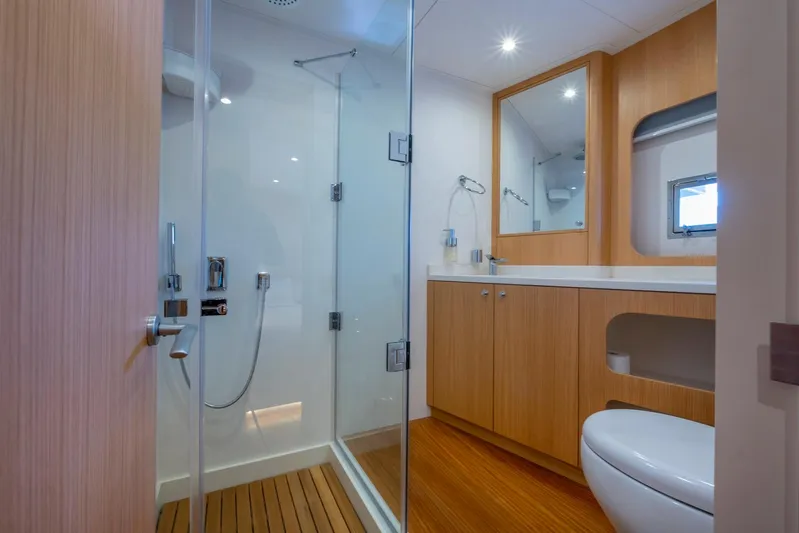  Yacht Photos Pics Modern bathroom on 2022 Custom 85 Semi Displacement Trawler with glass shower and wooden cabinetry.