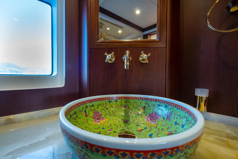  Yacht Photos Pics Decorative sink in 2022 Custom 85 Semi Displacement Trawler bathroom, featuring floral design and elegant fixtures.