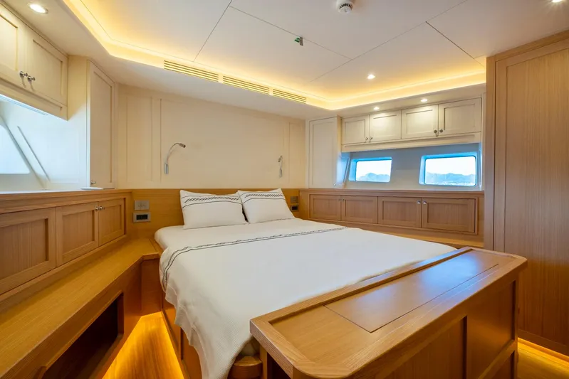  Yacht Photos Pics Luxurious bedroom interior of 2022 Custom 85 Semi Displacement Trawler with wood finish and ambient lighting.
