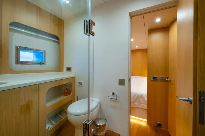  Yacht Photos Pics Modern bathroom on 2022 Custom 85 Semi Displacement Trawler, featuring sleek wood finishes and compact design.