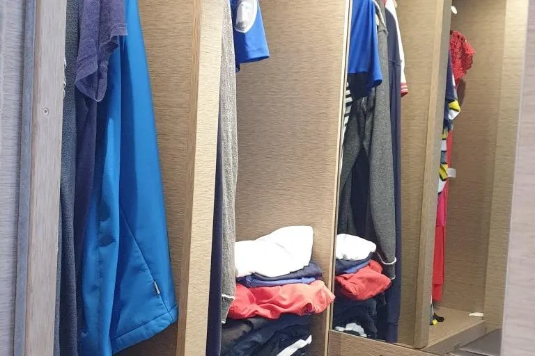 Jamap Yacht Photos Pics Closet interior with neatly arranged clothes on a 2016 Prestige 550 Fly yacht.