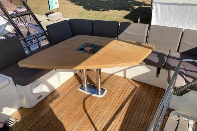 Jamap Yacht Photos Pics 2016 Prestige 550 Fly yacht deck with wooden table and cushioned seating.