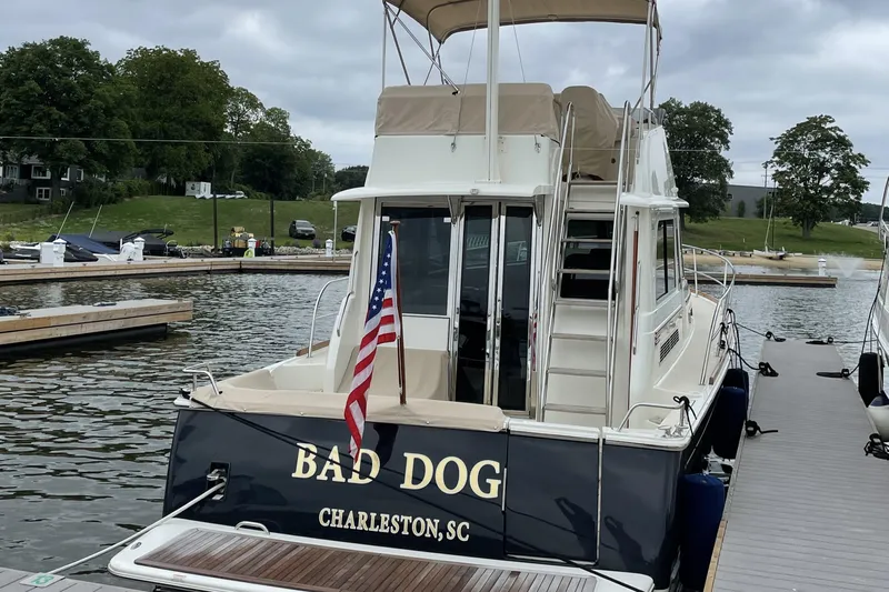 Bad Dog Yacht Photos Pics 2021 Sabre 42 Fly Bridge yacht docked, featuring "Bad Dog" name and American flag.
