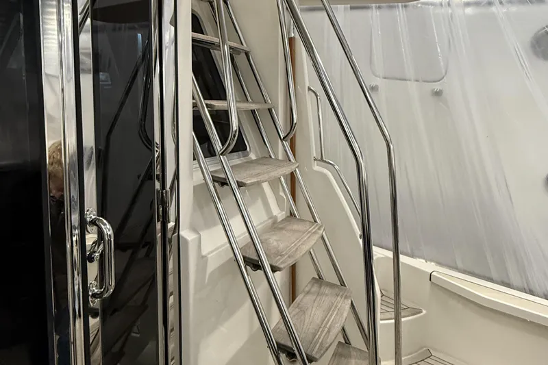Bad Dog Yacht Photos Pics Staircase on 2021 Sabre 42 Fly Bridge yacht with sleek metal railings.