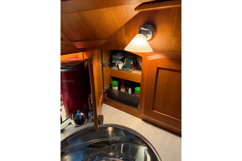 Bad Dog Yacht Photos Pics Interior of 2021 Sabre 42 Fly Bridge yacht kitchen with wooden cabinets and lighting.