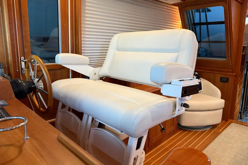 Bad Dog Yacht Photos Pics Captain's chair on 2021 Sabre 42 Fly Bridge, featuring luxurious white upholstery and wooden accents.
