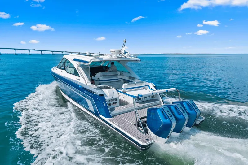  Yacht Photos Pics 2024 Formula 380 Super Sport Crossover cruising on open water under a clear blue sky.