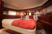 Luxurious bedroom interior of 1997 Arno Leopard 27m yacht with red accents and elegant decor.