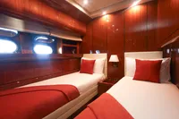 Luxurious twin cabin on 1997 Arno Leopard 27m yacht with elegant wood paneling.
