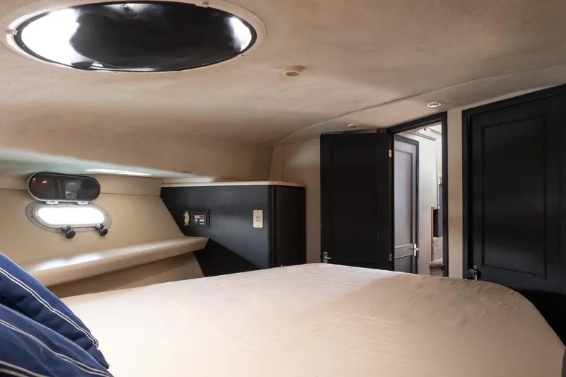  Yacht Photos Pics Interior cabin of 2001 Bayliner 3788 Command Bridge Motoryacht, featuring a cozy bed and porthole.