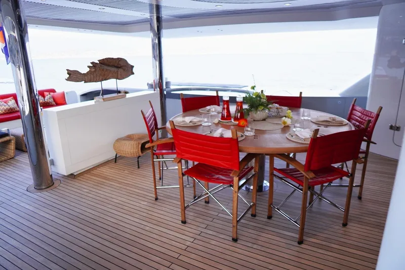 Euphoria II Yacht Photos Pics Luxurious Mayra Yachts 50m deck with elegant dining setup, red chairs, and ocean view.