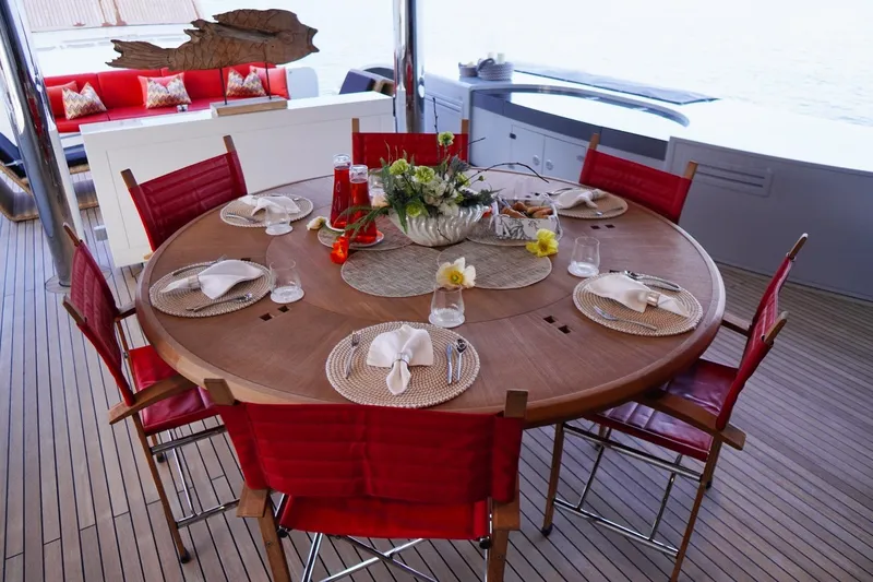 Euphoria II Yacht Photos Pics Luxurious dining setup on 2016 Mayra Yachts 50m, featuring red chairs and elegant tableware.