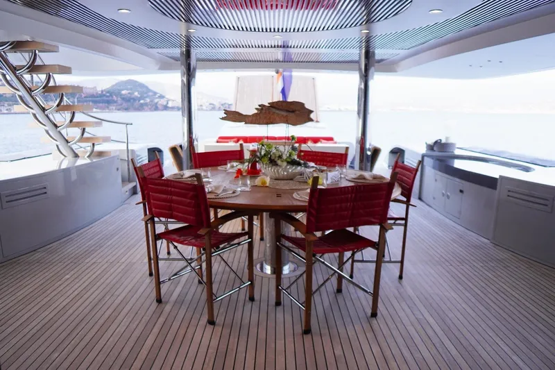 Euphoria II Yacht Photos Pics Luxurious dining area on 2016 Mayra Yachts 50m, featuring elegant red chairs and scenic views.