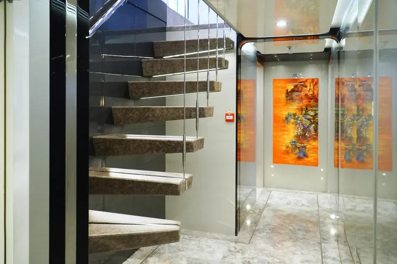 Euphoria II Yacht Photos Pics Luxurious interior of 2016 Mayra Yachts 50m, featuring modern staircase and vibrant artwork.