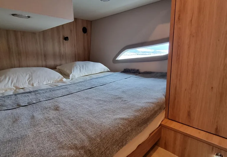 Monachus 470 Fly Yacht Photos Pics Cozy cabin interior of 2026 Monachus 470 FLY yacht with bed and window view.
