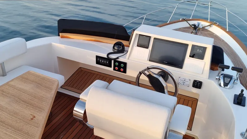 Monachus 470 Fly Yacht Photos Pics 2026 Monachus 470 FLY yacht helm with modern controls and wooden accents.