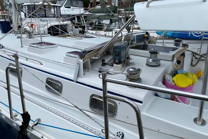 Caneel Yacht Photos Pics 2007 Valiant 50 sailboat deck with winches, ropes, and storage containers at a marina.