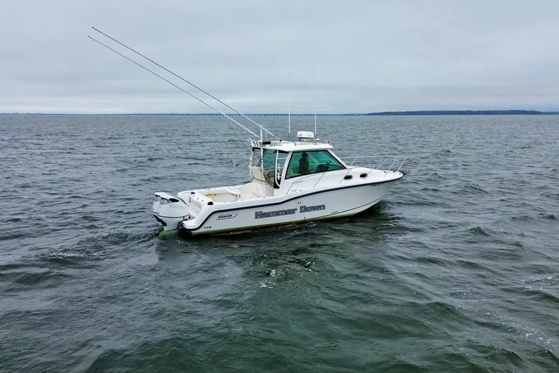Hammer Down Yacht Photos Pics 2016 Boston Whaler 315 Conquest boat on open water, overcast sky.