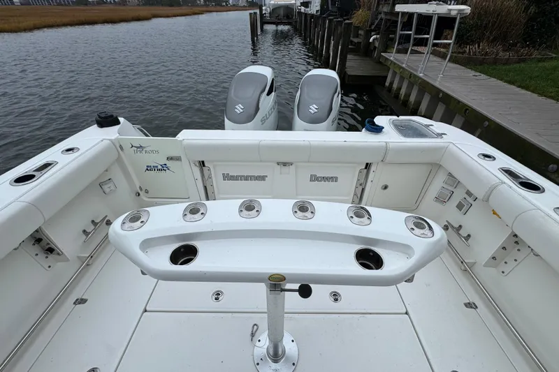 Hammer Down Yacht Photos Pics 2016 Boston Whaler 315 Conquest boat with dual Suzuki outboard engines, docked by a wooden pier.