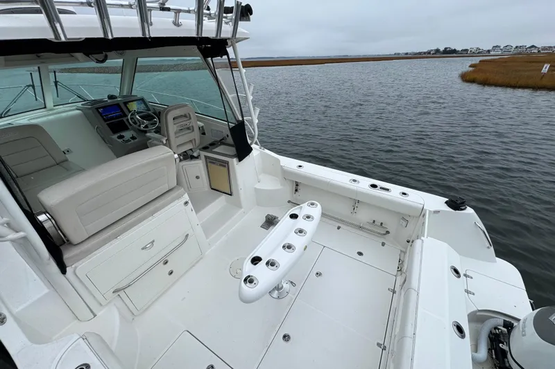 Hammer Down Yacht Photos Pics 2016 Boston Whaler 315 Conquest boat interior with helm and seating, docked on calm water.