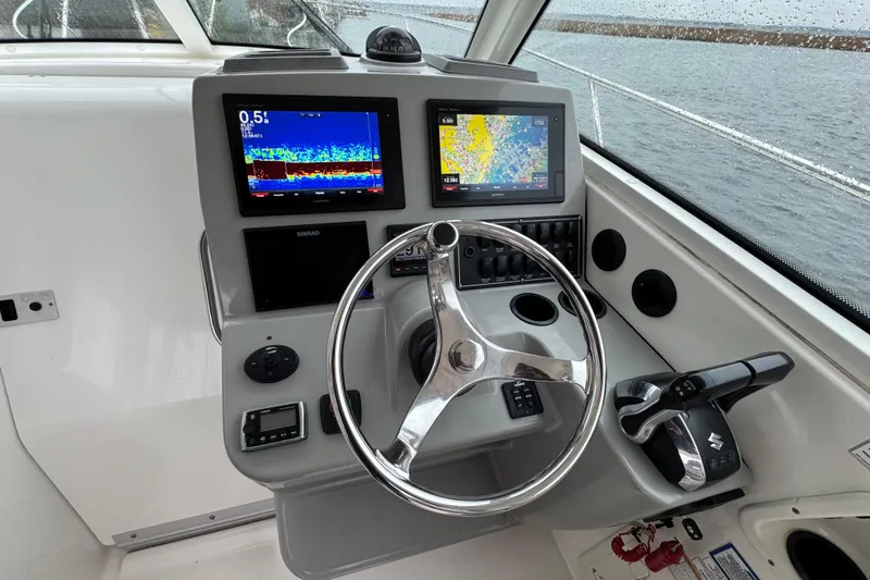 Hammer Down Yacht Photos Pics 2016 Boston Whaler 315 Conquest helm with dual navigation screens and steering wheel.