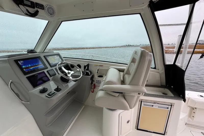 Hammer Down Yacht Photos Pics 2016 Boston Whaler 315 Conquest helm with modern navigation displays and comfortable seating.
