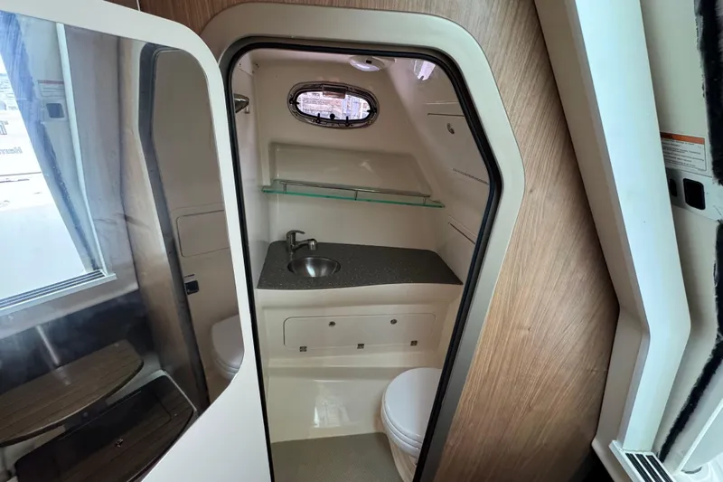 Hammer Down Yacht Photos Pics 2016 Boston Whaler 315 Conquest boat bathroom with sink and porthole window.