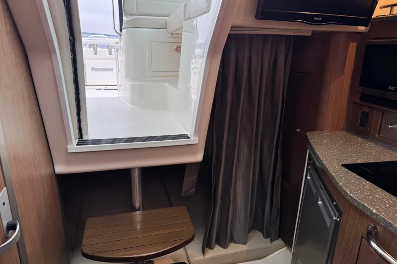 Hammer Down Yacht Photos Pics Interior view of a 2016 Boston Whaler 315 Conquest boat cabin with seating and kitchenette.