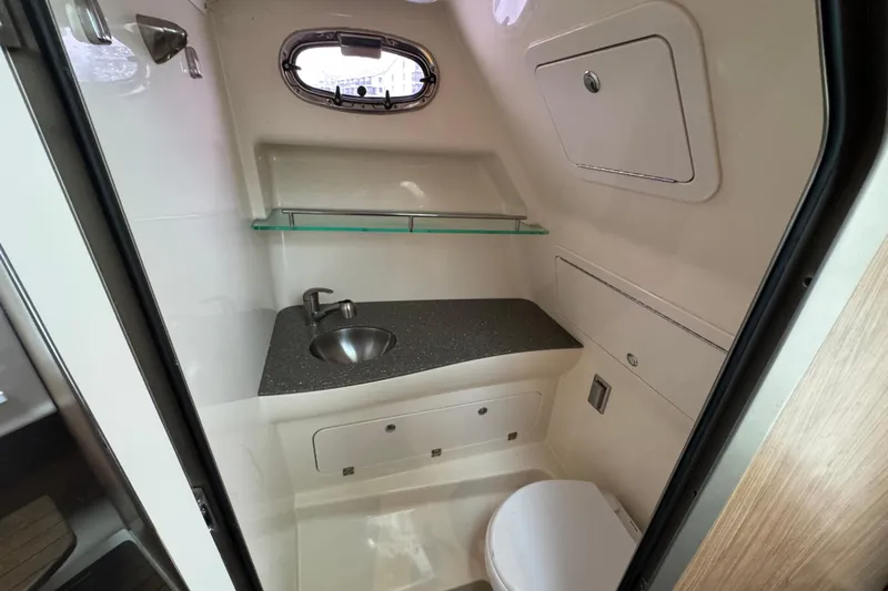 Hammer Down Yacht Photos Pics 2016 Boston Whaler 315 Conquest bathroom with sink, toilet, and storage.