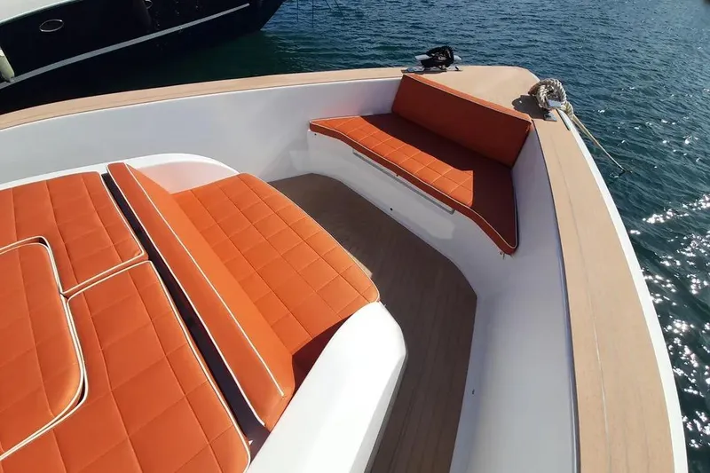 Ban Ban Yacht Photos Pics Luxurious 2023 Pardo Yachts 50 with orange cushioned seating on deck, docked by the water.