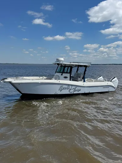 Nauti Time Yacht Photos Pics 2024 World Cat 325 CC boat cruising on open water under a clear blue sky.
