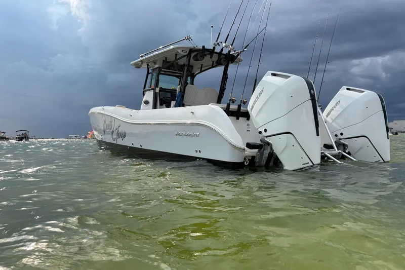 Nauti Time Yacht Photos Pics 2024 World Cat 325 CC boat with dual Mercury engines on water under cloudy sky.