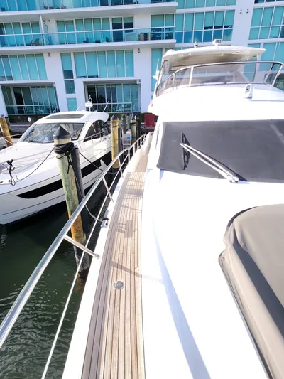  Yacht Photos Pics 2014 Azimut Flybridge yacht docked beside modern waterfront building.