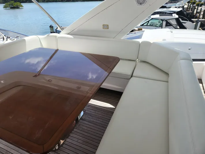  Yacht Photos Pics 2014 Azimut Flybridge yacht with elegant seating and polished wooden table on deck.