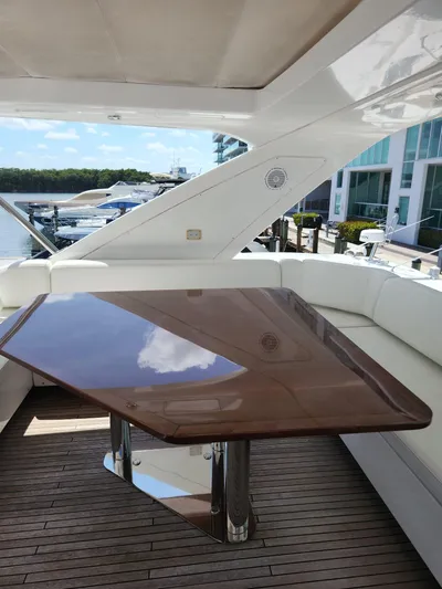  Yacht Photos Pics 2014 Azimut Flybridge yacht with sleek wooden table and white seating on deck.
