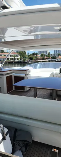  Yacht Photos Pics 2014 Azimut Flybridge yacht deck with seating and table, overlooking waterfront homes.