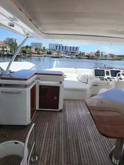  Yacht Photos Pics 2014 Azimut Flybridge yacht interior with wooden deck and modern controls, overlooking waterfront.