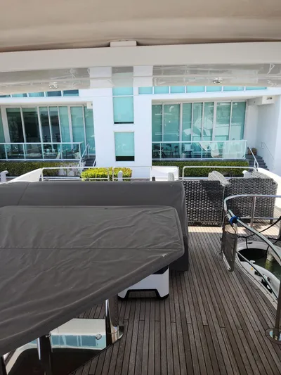  Yacht Photos Pics Azimut Flybridge 2014 yacht deck with covered seating and modern architecture in the background.
