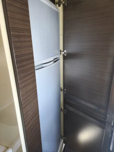  Yacht Photos Pics 2014 Azimut Flybridge yacht interior with a built-in refrigerator in a wooden cabinet.