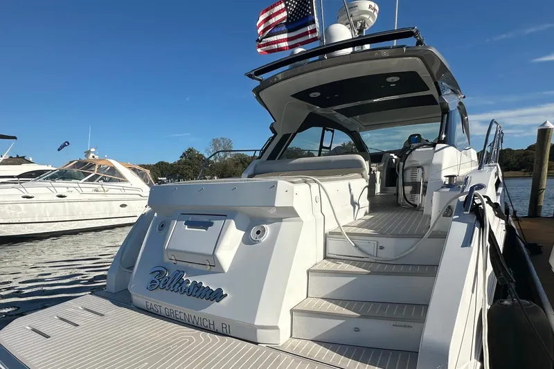 Bellisima Yacht Photos Pics 2019 Azimut Atlantis 51 yacht docked, rear view with American flag, sunny day.